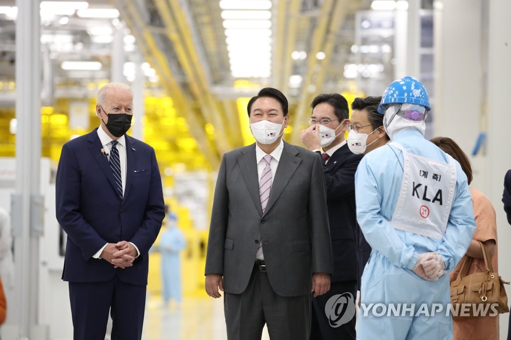 Le président Yoon Suk-yeol (2e depuis la g.) et le président américain Joe Biden (à g.) visitent une usine de puces de Samsung Electronics à Pyeongtaek, à 70 kilomètres au sud de Séoul, le vendredi 20 mai 2022, guidés par Lee Jae-yong, le dirigeant de facto du groupe Samsung et vice-président de Samsung Electronics.