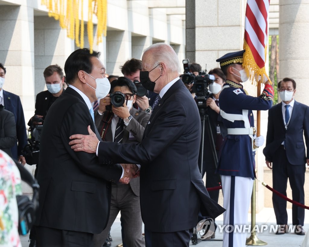 President Yoon Suk-yeol (L) and U.S. President Joe Biden greet each other as Biden arrives for their first summit at the presidential office in Yongsan, Seoul, on May 21, 2022. (Yonhap)