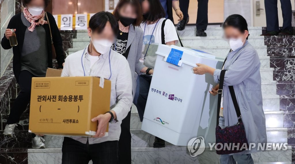 Election officials move ballot boxes at a polling station in central Seoul on May 28, 2022 as two-day early voting for the June 1 local elections wrapped up. (Yonhap)