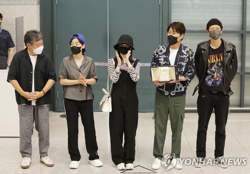 L'acteur Song Kang-ho (2e à partir de la droite), le réalisateur Hirokazu Kore-eda (1er à partir de la gauche) et d'autres membres du film «Broker» posent à leur arrivée à l'aéroport international d'Incheon, à Incheon, à l'ouest de Séoul, le 30 mai 2022. (Yonhap)