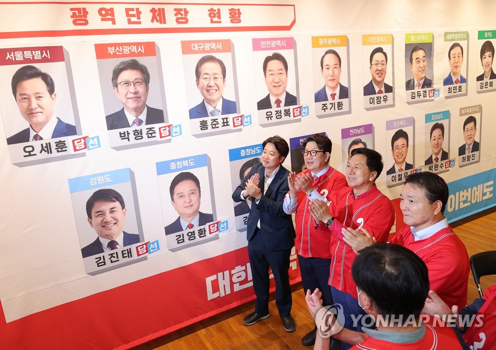 統一地方選で、当選が有力視される自治体首長候補の写真に「当選」のシールを貼って喜ぶ「国民の力」幹部ら（国会写真記者団）＝２日、ソウル（聯合ニュース）