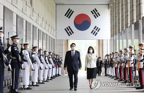 El presidente surcoreano, Yoon Suk-yeol (izda.), y la primera dama, Kim Keon-hee, pasan caminando por delante de un cenotafio con los nombres de los caídos de guerra en el Monumento Conmemorativo de la Guerra de Corea, en Seúl, el 17 de junio de 2022, antes de un almuerzo con personas de mérito nacional y sus familiares.