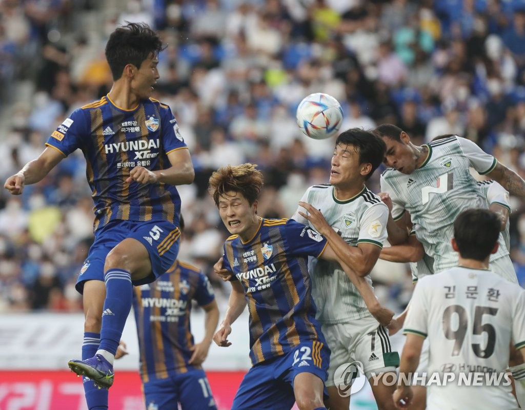 Players for Ulsan Hyundai FC (in blue) and Jeonbuk Hyundai Motors vie for the ball during the clubs' K League 1 match at Munsu Football Stadium in Ulsan, 310 kilometers southeast of Seoul, on June 19, 2022. (Yonhap)