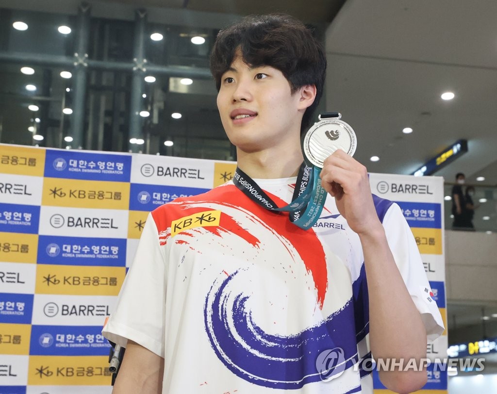South Korean swimmer Hwang Sun-woo holds up his silver medal from the men's 200m freestyle at the FINA World Championships in Budapest, after arriving at Incheon International Airport in Incheon, just west of Seoul, on June 27, 2022. (Yonhap)