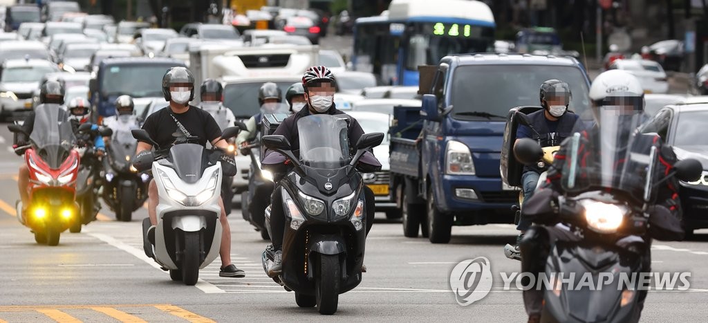 La foto de archivo, tomada el 28 de junio de 2022, muestra a repartidores en motocicletas en una calle de Seúl. 
