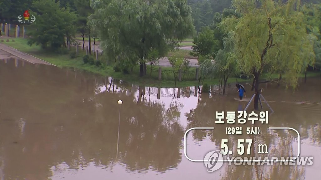This photo, captured from North Korea's state-run Korean Central Television on June 29, 2022, shows a man walking through a flooded street near the Pothong River basin in Pyongyang, submerged after three days of torrential rains. The network reported that 233.7 millimeters of rain hit the area between 7 p.m. on June 27 and 5 a.m. on June 29, with the river's water level reaching as high as 5.57 meters and surpassing the danger level of 5.46 meters. (For Use Only in the Republic of Korea. No Redistribution) (Yonhap)