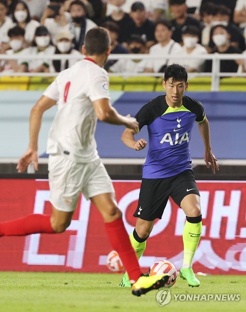 Son Heung-min (R) of Tottenham Hotspur dribbles the ball against Sevilla FC during the clubs' preseason match at Suwon World Cup Stadium in Suwon, Gyeonggi Province, on July 16, 2022. (Yonhap)
