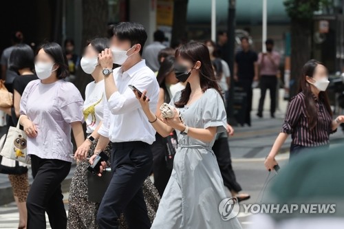 La foto de archivo, sin fechar, muestra a ciudadanos surcoreanos con mascarillas en una calle de Seúl.