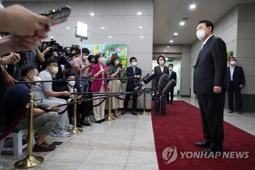 Le président Yoon Suk-yeol répond le lundi 8 août 2022 à des questions de journalistes à son arrivée au bureau présidentiel après une semaine de vacances. (Pool photo) 