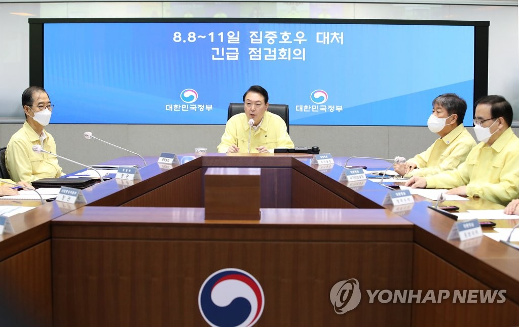 President Yoon Suk-yeol (C) presides over a meeting at the government complex in Seoul on Aug. 9, 2022, to check damage by torrential rainfall that battered Seoul and surrounding areas the previous night. Over 100 millimeters per hour fell the previous night, the heaviest downpour in 80 years. (Yonhap)