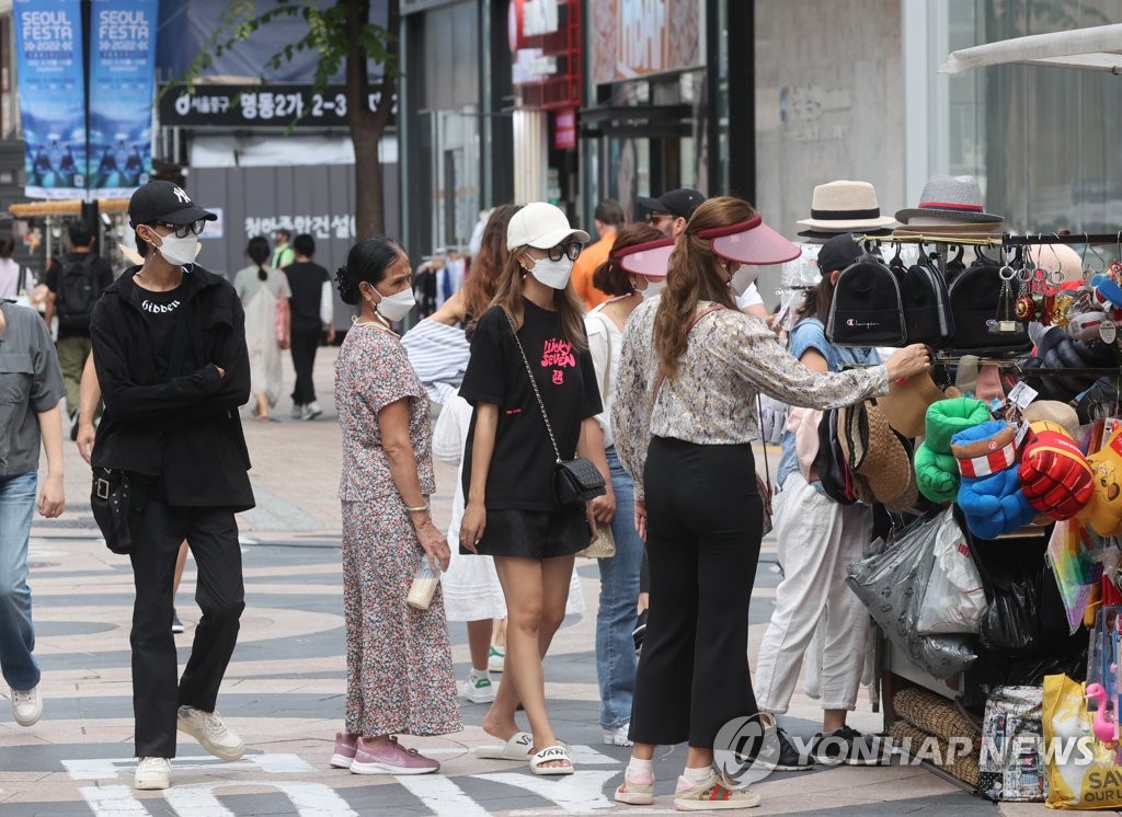 This undated file photo shows foreign tourists shopping in Seoul's Myeongdong district. (Yonhap)