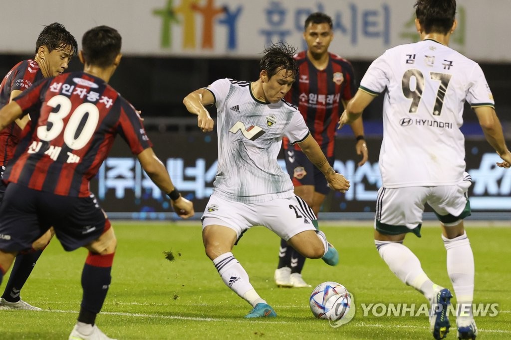 Song Min-kyu of Jeonbuk Hyundai FC (C) takes a shot against Suwon FC during the clubs' K League 1 match at Suwon Stadium in Suwon, 35 kilometers south of Seoul, on Aug. 10, 2022. (Yonhap)