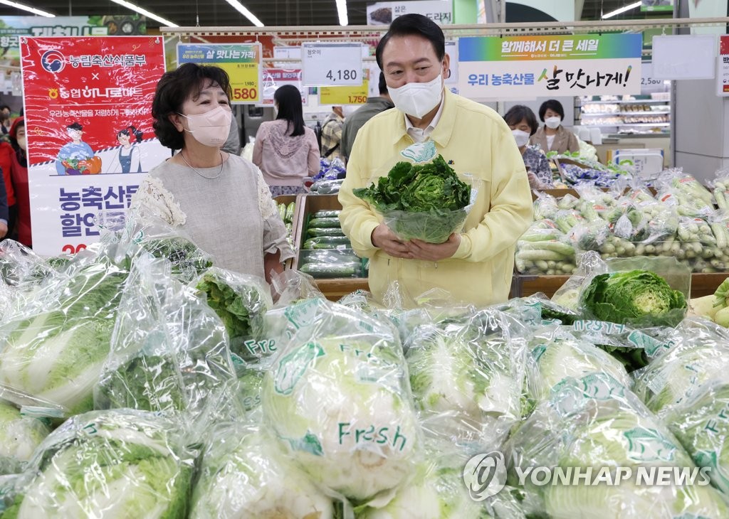 President Yoon Suk-yeol (R) checks vegetable prices at a discount supermarket in southern Seoul on Aug. 11, 2022. (Yonhap)