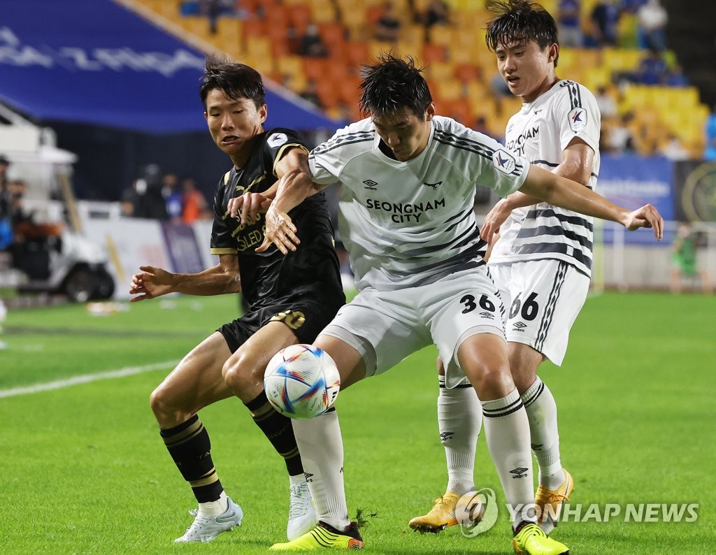 Ryu Seung-woo of Suwon Samsung Bluewings (L) and Kim Ji-soo of Seongnam FC vie for the ball during the clubs' K League 1 match at Suwon World Cup Stadium in Suwon, around 35 kilometers south of Seoul, on Aug. 14, 2022. (Yonhap)