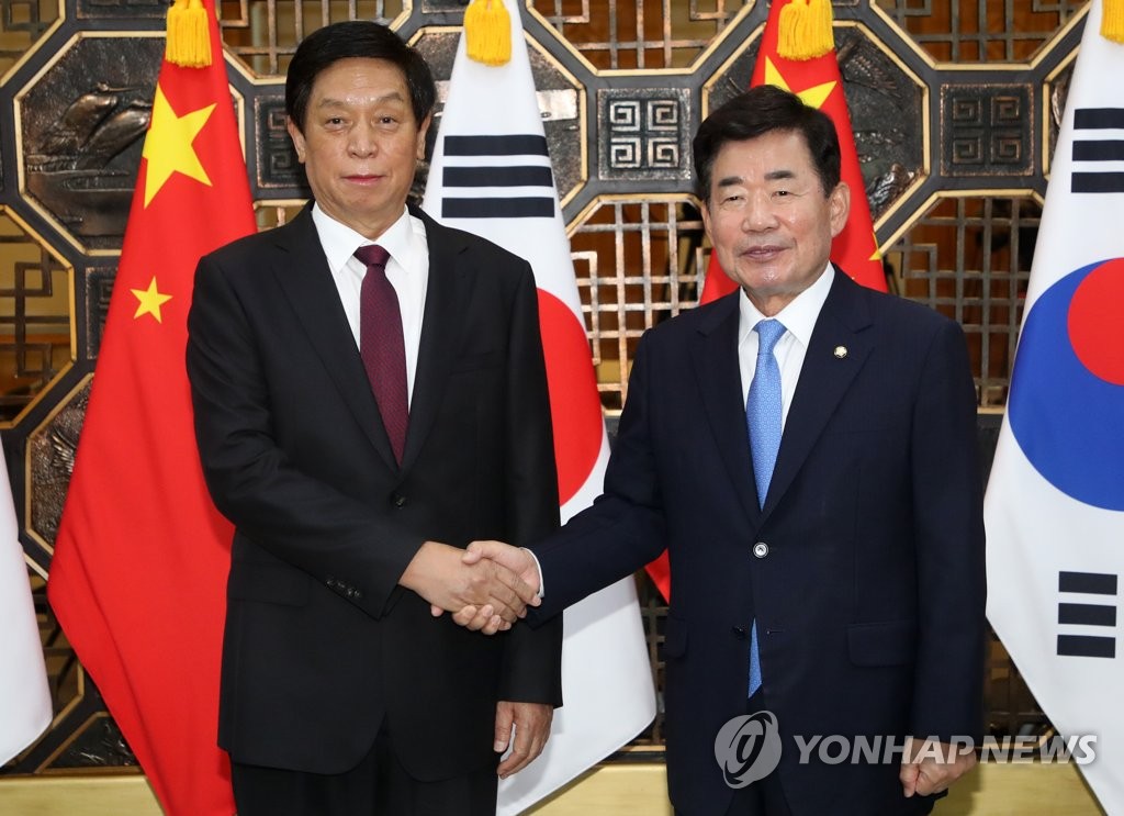 National Assembly Speaker Kim Jin-pyo (R) and Li Zhanshu, China's third-highest-ranking official and chief of the Standing Committee of the National People's Congress, shake hands ahead of their meeting at the National Assembly on Sept. 16, 2022. (Pool photo) (Yonhap)