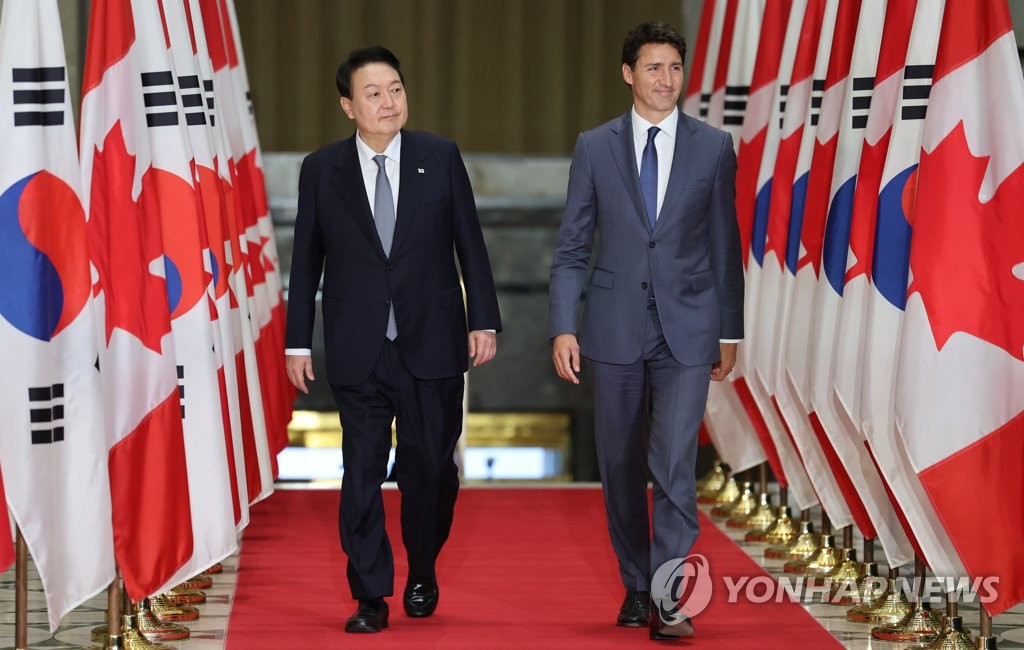 South Korean President Yoon Suk-yeol (L) and Canadian Prime Minister Justin Trudeau walk to the venue of their joint press conference inside the Sir John A. Macdonald Building in Ottawa on Sept. 23, 2022. (Yonhap)
