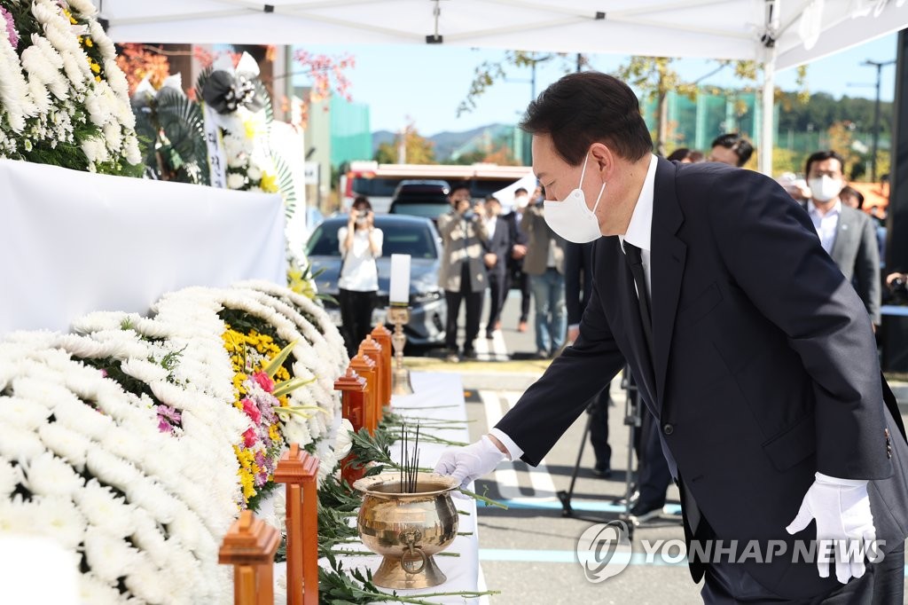 President Yoon Suk-yeol lays a flower on Sept. 27, 2022, at a joint mourning altar for the seven people who died in a fire at an outlet mall in Daejeon the previous day, in this photo provided by his office. (PHOTO NOT FOR SALE) (Yonhap)