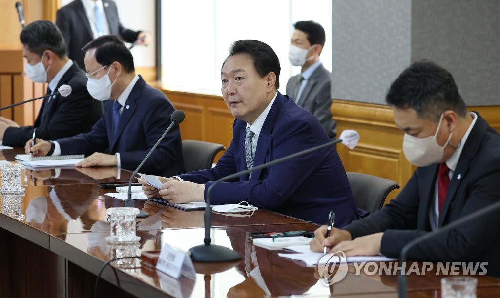 El presidente, Yoon Suk-yeol (2º por la dcha.), habla durante una reunión macrofinanciera con funcionarios y representantes empresariales, el 30 de septiembre de 2022, en un centro financiero, en el centro de Seúl.