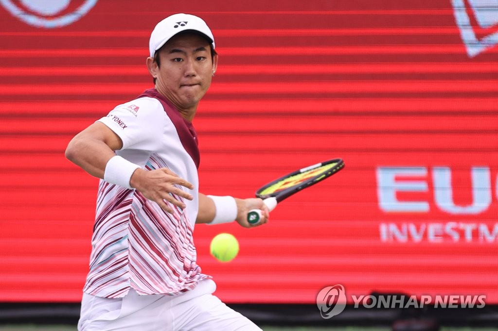 Yoshihito Nishioka of Japan hits a shot to Denis Shapovalov of Canada during the men's singles final at the ATP Eugene Korea Open at Olympic Park Tennis Center in Seoul on Oct. 2, 2022. (Yonhap)