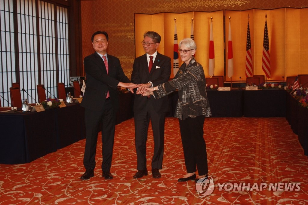 El primer viceministro de Asuntos Exteriores surcoreano, Cho Hyun-dong (izda.), y sus homólogos de EE. UU. y Japón -Wendy Sherman (dcha.) y Takeo Mori, respectivamente- juntan las manos, el 25 de octubre de 2022, al comienzo de una reunión trilateral de consultas, en Tokio, Japón.