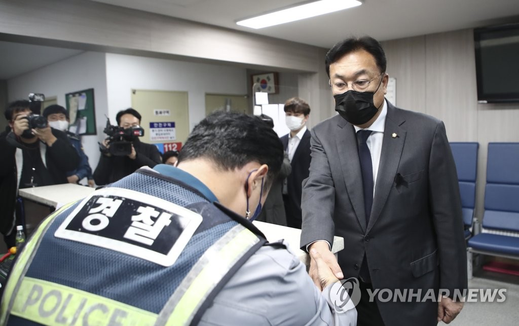 Chung Jin-suk (R), the ruling People Power Party interim chief, shakes hands with a police officer during his visit to police precinct in Itaewon, central Seoul, where the deadly crowd crush happened, on Nov. 9, 2022. (Pool photo) (Yonhap)