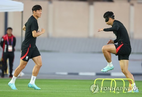 Hwang Ui-jo (L) and Son Heung-min of South Korea train for the FIFA World Cup at Al Egla Training Site in Doha on Nov. 22, 2022. (Yonhap)