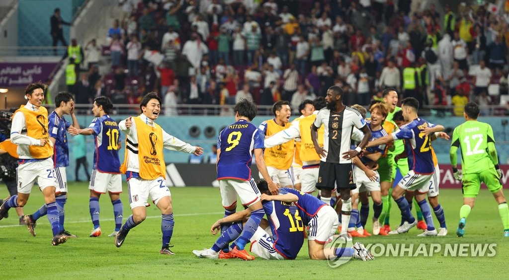 Japanese players celebrate their 2-1 victory over Germany in their Group E match at the FIFA World Cup at Khalifa International Stadium in Al Rayyan, west of Doha, on Nov. 23, 2022. (Yonhap)