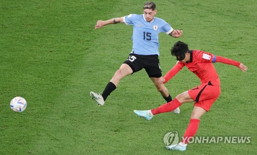 Son Heung-min of South Korea (R) takes a shot against Uruguay during the countries' Group H match at the FIFA World Cup at Education City Stadium in Al Rayyan, west of Doha, on Nov. 24, 2022. (Yonhap)