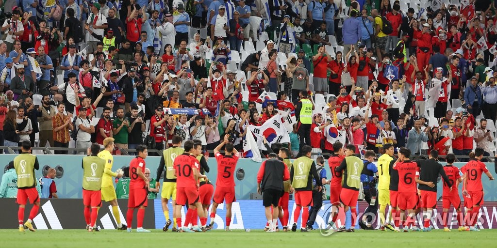Los jugadores surcoreanos saludan a sus seguidores, el 24 de noviembre de 2022, al término de un empate sin goles, contra Uruguay, en el partido inaugural del Grupo H de la Copa Mundial, en el estadio de la Ciudad de la Educación, en Rayán, al oeste de Doha.