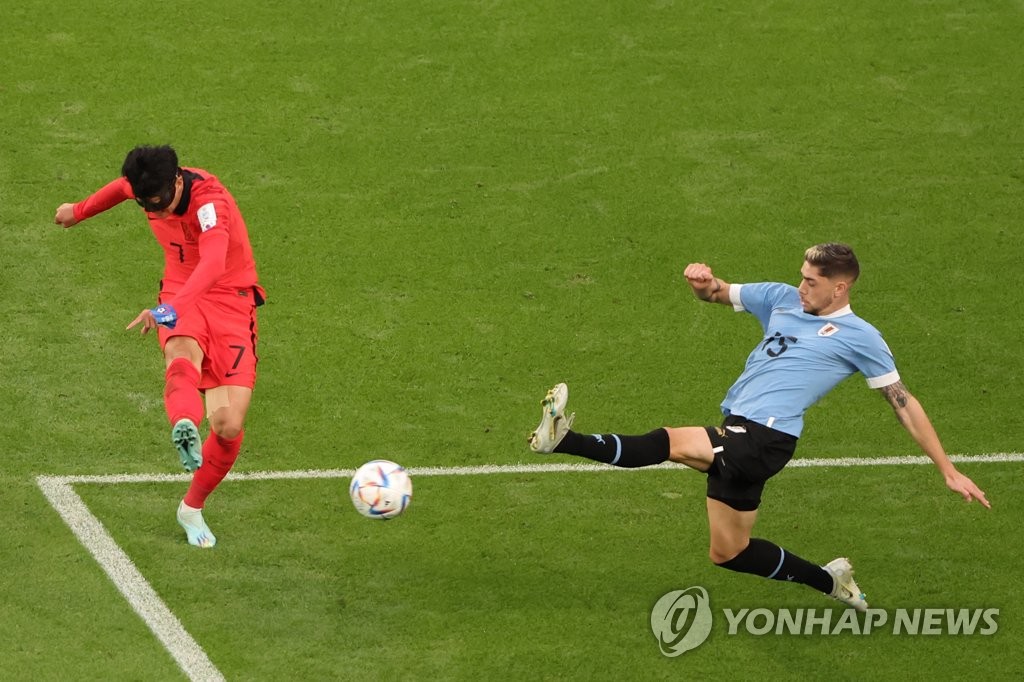 Son Heung-min of South Korea (L) takes a shot past Federico Valverde of Uruguay during the countries' Group H match at the FIFA World Cup at Education City Stadium in Al Rayyan, west of Doha, on Nov. 24, 2022. (Yonhap)