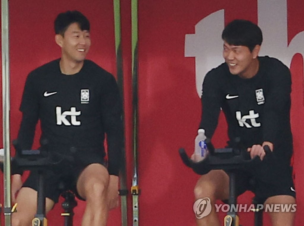 South Korean players Son Heung-min (L) and Kim Young-gwon ride stationary bicycles during a training session for the FIFA World Cup at Al Egla Training Site in Doha on Nov. 25, 2022. (Yonhap)