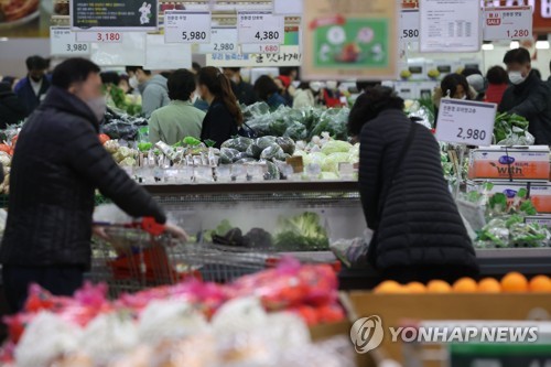 La foto, tomada el 27 de noviembre de 2022, muestra a ciudadanos escogiendo vegetales en un supermercado de Seúl.