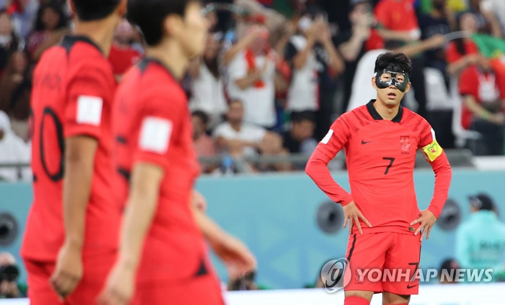 Son Heung-min of South Korea (R) reacts to a goal by Portugal during the countries' Group H match at the FIFA World Cup at Education City Stadium in Al Rayyan, west of Doha, on Dec. 2, 2022. (Yonhap)