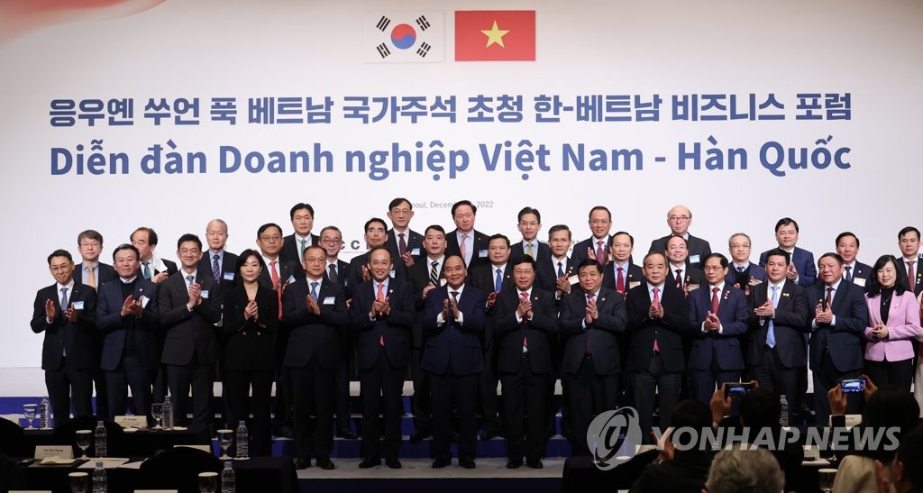 Finance Minister Choo Kyung-ho (6th from L) and Vietnamese President Nguyen Xuan Phuc, standing next to Choo, pose for a photo along with other government officials and businesspeople during a business forum in Seoul hosted by the Korea Chamber of Commerce and Industry on Dec. 6, 2022. (Yonhap) 