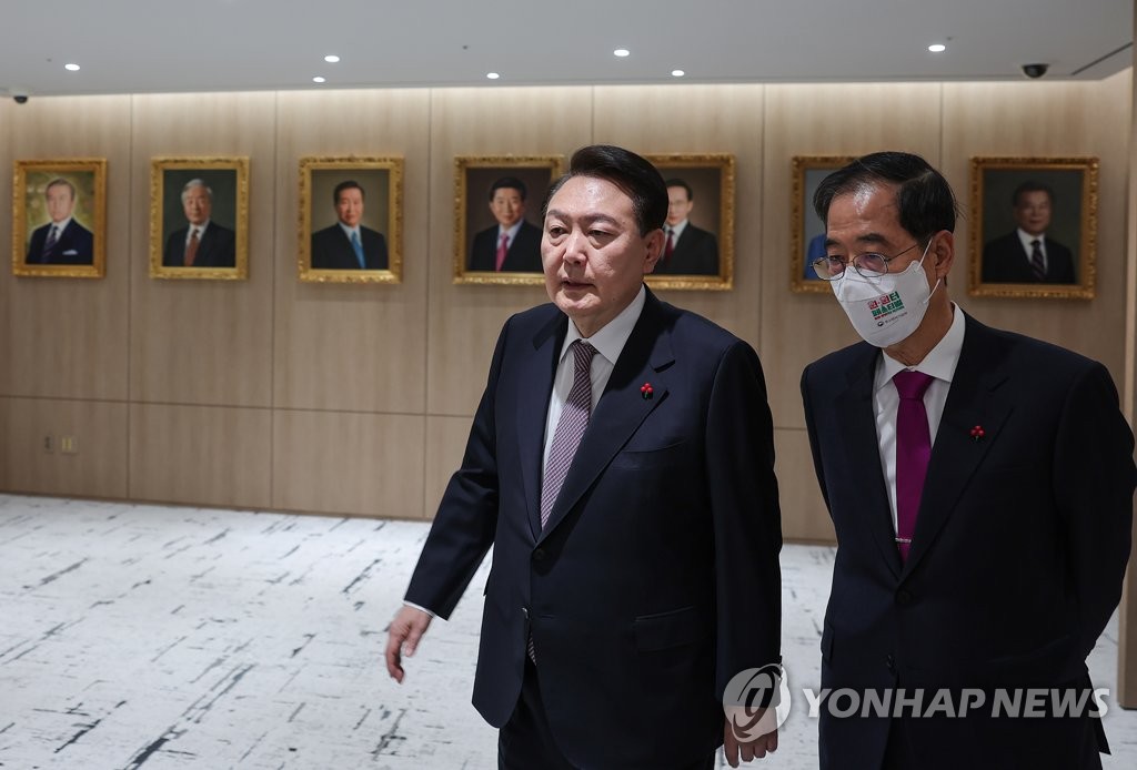 President Yoon Suk-yeol (L) and Prime Minister Han Duck-soo walk to a Cabinet meeting at the presidential office in Seoul on Dec. 13, 2022, in this photo provided by the office. (PHOTO NOT FOR SALE) (Yonhap)