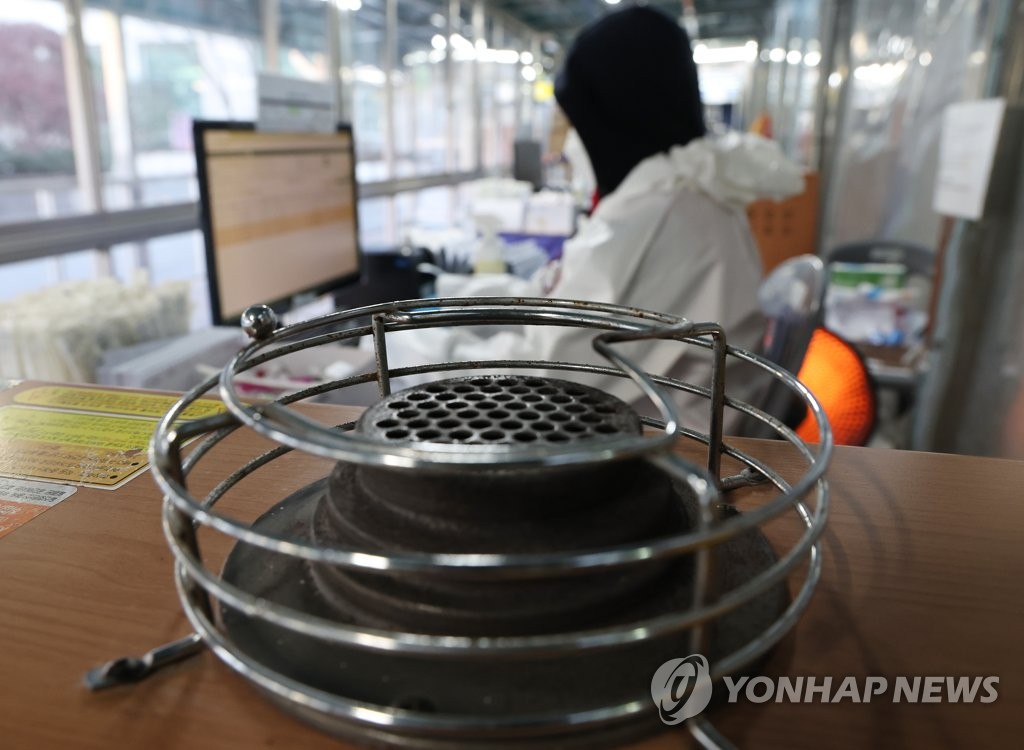 This photo taken on Dec. 14, 2022, shows a medical worker at a COVID-19 testing center in Dongdaemun, eastern Seoul, amid a cold wave. (Yonhap)