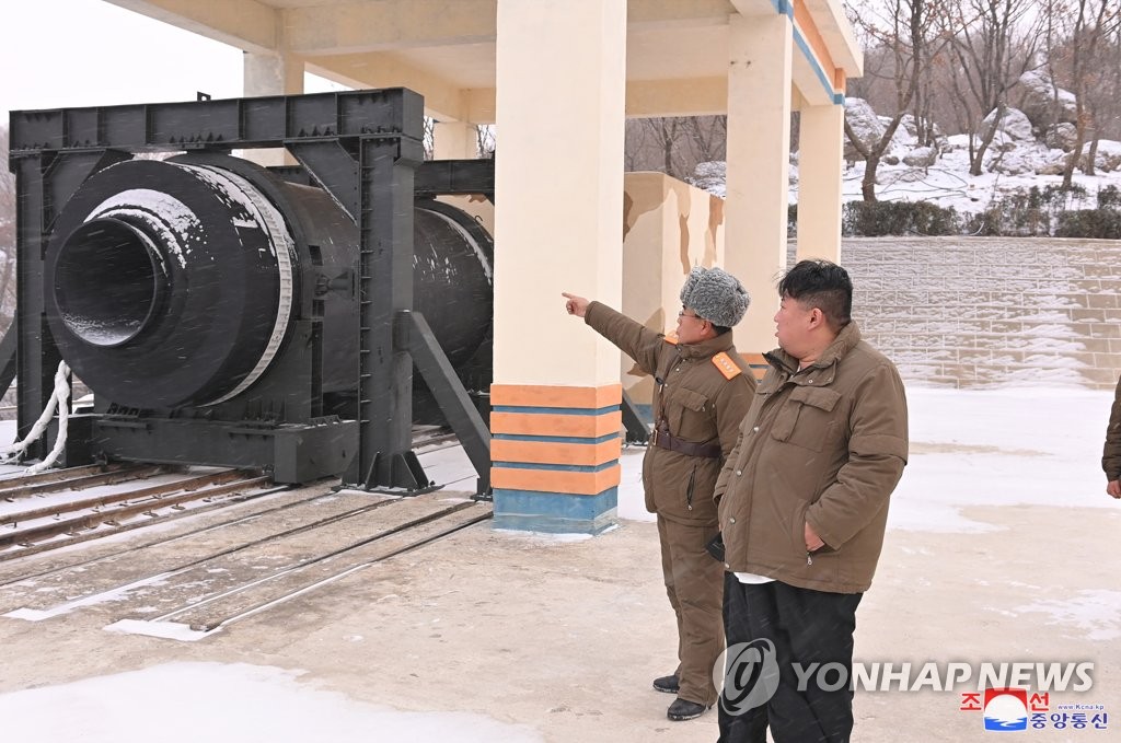 North Korean leader Kim Jong-un (R) inspects a ground test of a "high-thrust solid-fuel motor" at Sohae Satellite Launching Ground in Cholsan, North Pyongan Province, on Dec. 15, 2022, in this photo released by the Korean Central News Agency the next day. (For Use Only in the Republic of Korea. No Redistribution) (Yonhap)