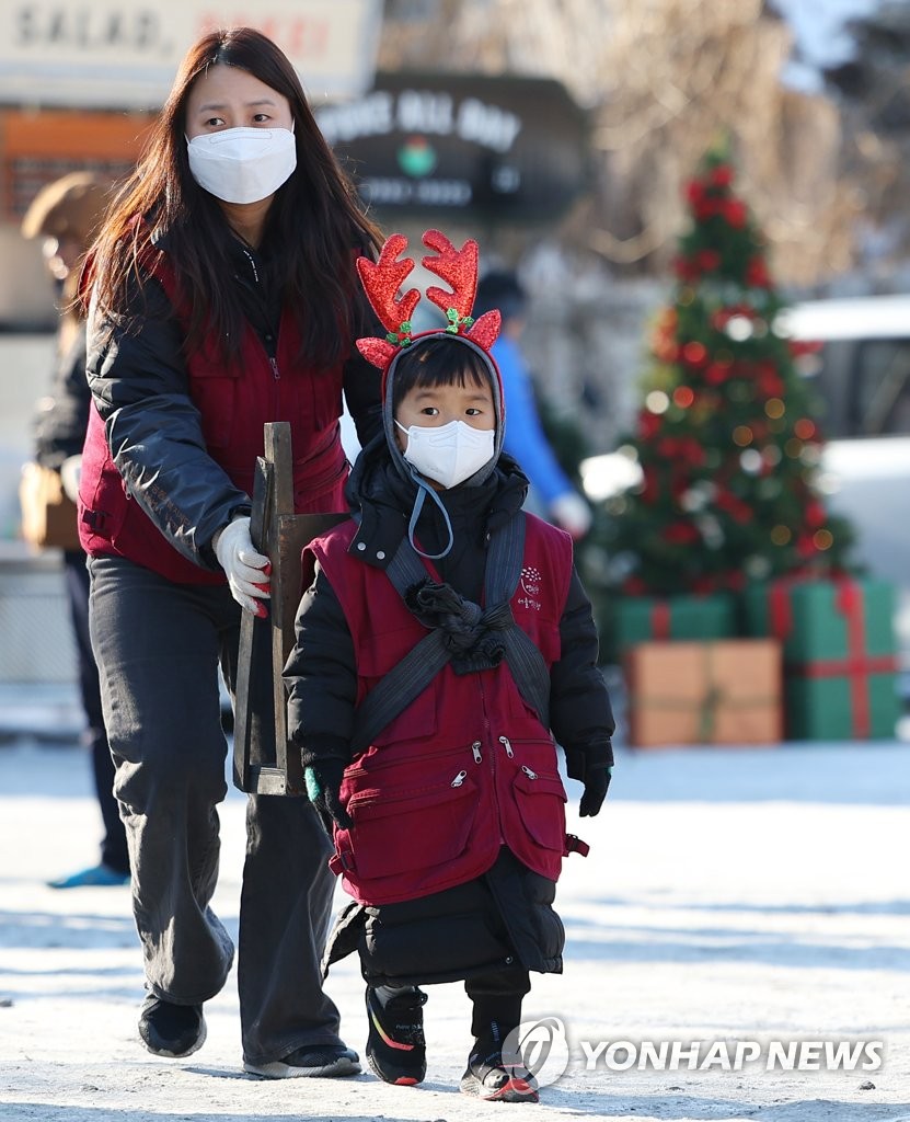 엄마 도움 받으며 연탄 옮기는 어린이