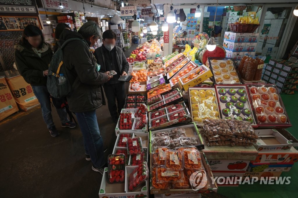 서울시내 한 전통시장에서 과일을 고르는 시민들