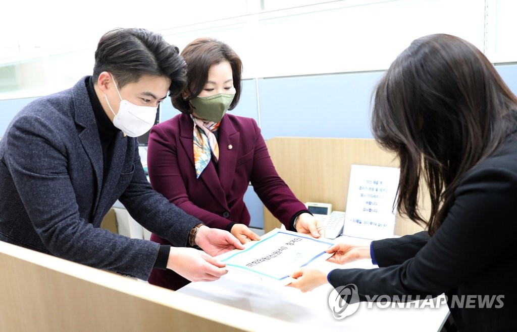Rep. Oh Yeong-hwan (L) and Rep. Lee Soo-jin (C) of the main opposition Democratic Party submit a penalty motion against Rep. Shin Won-sik of the ruling People Power Party to the National Assembly in Seoul on Jan. 9, 2023. (Pool photo) (Yonhap)