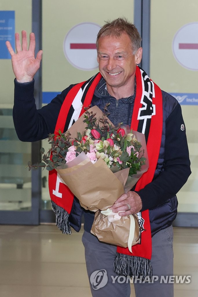 Jurgen Klinsmann, new head coach of the South Korean men's national football team, waves to the cameras after arriving at Incheon International Airport, west of Seoul, on March 8, 2023. (Yonhap)
