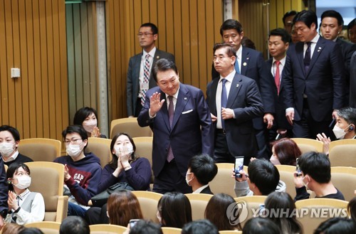 El presidente de Corea del Sur, Yoon Suk Yeol (centro, de pie), quien se encuentra de visita en Japón, saluda a los estudiantes, el 17 de marzo de 2023, durante una visita a la Universidad de Keio, en Tokio, para dar una charla especial.