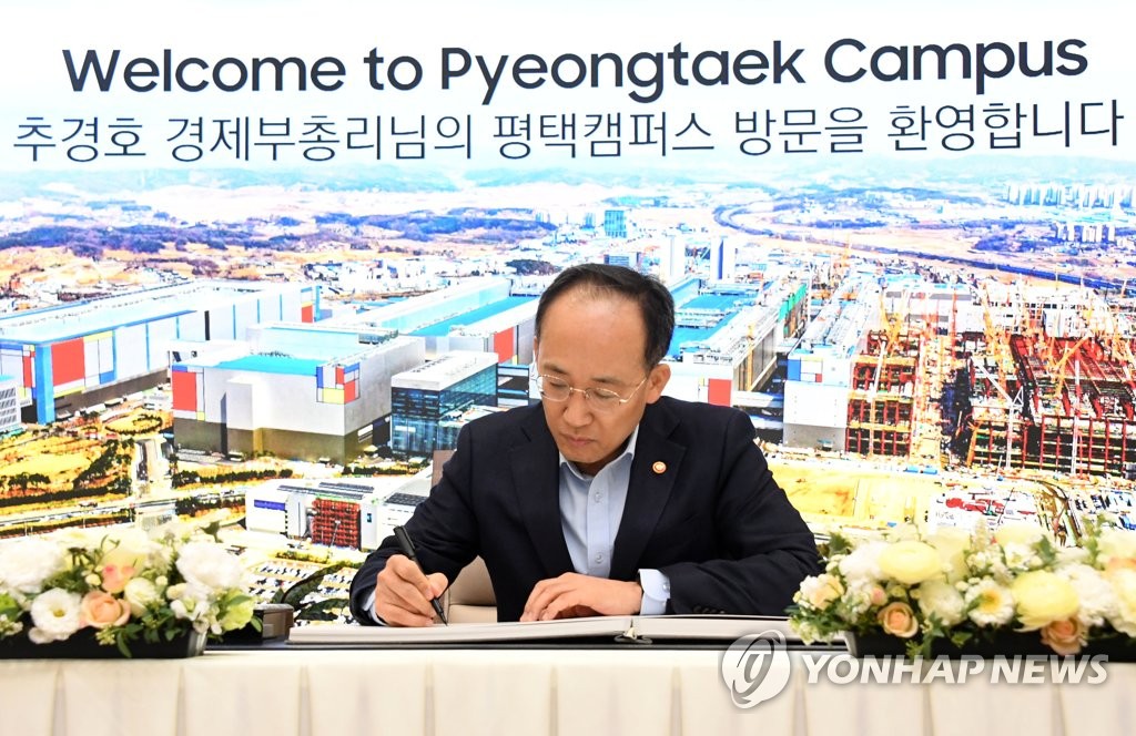 Finance Minister Choo Kyung-ho, signs a visitor's book at Samsung Electronics Co.'s production line in Pyeongtaek, 65 kilometers south of Seoul, on April 7, 2023, in this photo provided by the finance ministry. (PHOTO NOT FOR SALE) (Yonhap)