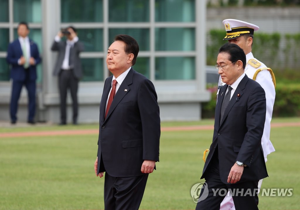 President Yoon Suk Yeol (L) and Japanese Prime Minister Fumio Kishida (R) inspect an honor guard during an official arrival ceremony for the Japanese leader at the presidential office in Seoul on May 7, 2023. (Yonhap)
