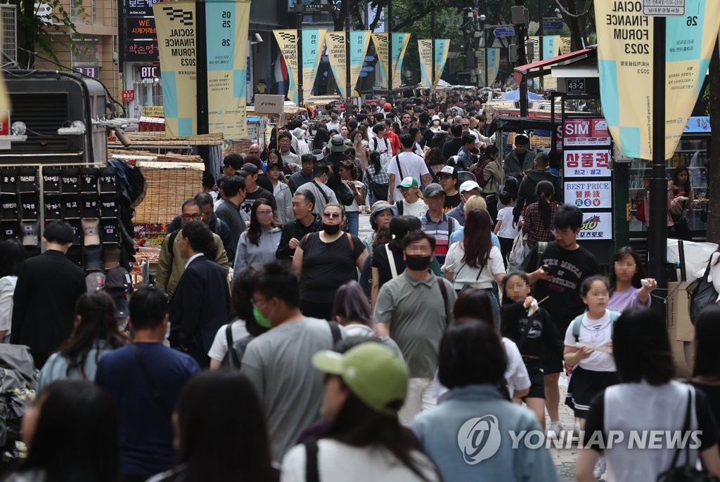 Une rue fréquentée du quartier de Myeongdong, dans le centre de Séoul, est rempli de touristes étrangers, le dimanche 21 mai 2023.