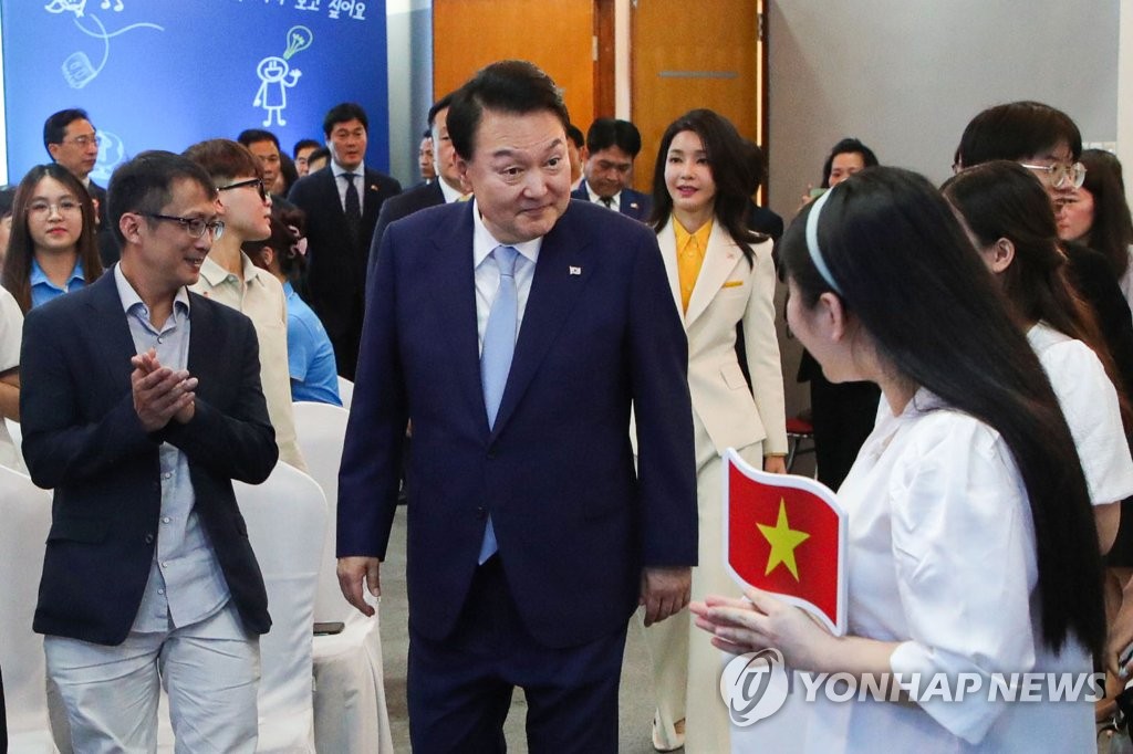 Tổng thống Hàn Quốc Yoon Suk Yeol (giữa, trước) và đệ nhất phu nhân Kim Keon Hee (giữa, sau) gặp gỡ nhóm sinh viên Việt Nam học tiếng Hàn tại Đại học Quốc gia Hà Nội, ngày 22/6/2023. (Yonhap)