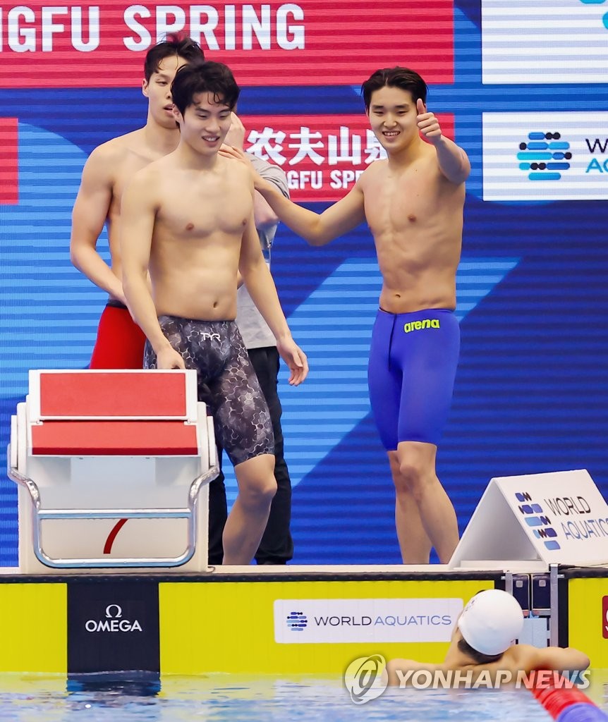South Korean swimmers Yang Jae-hoon, Hwang Sun-woo and Kim Woo-min (L to R) celebrate after teammate Lee Ho-joon (in water) completed the final leg of the men's 4x200-meter freestyle relay for the national record time of 7:04.07 in the final at the World Aquatics Championships at Marine Messe Fukuoka Hall A in Fukuoka, Japan, on July 28, 2023. (Yonhap)