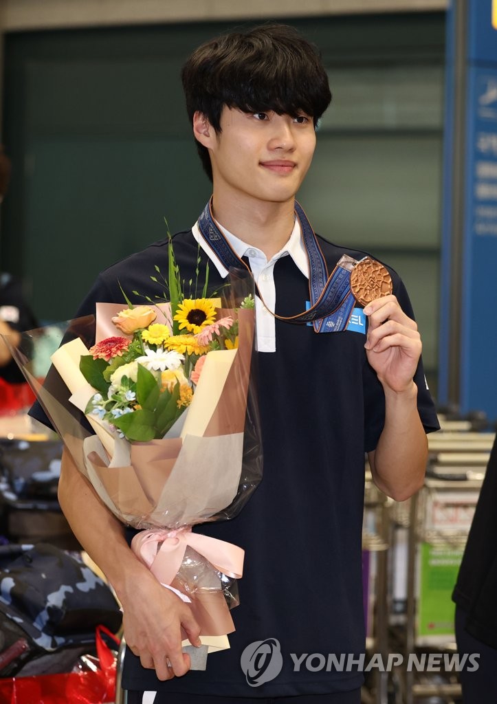 South Korean swimmer Hwang Sun-woo holds up his bronze medal won from the men's 200-meter freestyle at the World Aquatics Championships in Fukuoka, Japan, upon arriving at Incheon International Airport, west of Seoul, on July 31, 2023. (Yonhap)