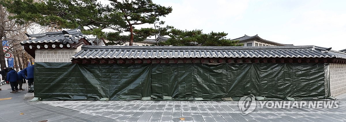 Los grafitis pintados en las paredes del Palacio Gyeongbok, en el centro de Seúl, han sido cubiertos temporalmente por funcionarios el 16 de diciembre de 2023. (Yonhap)