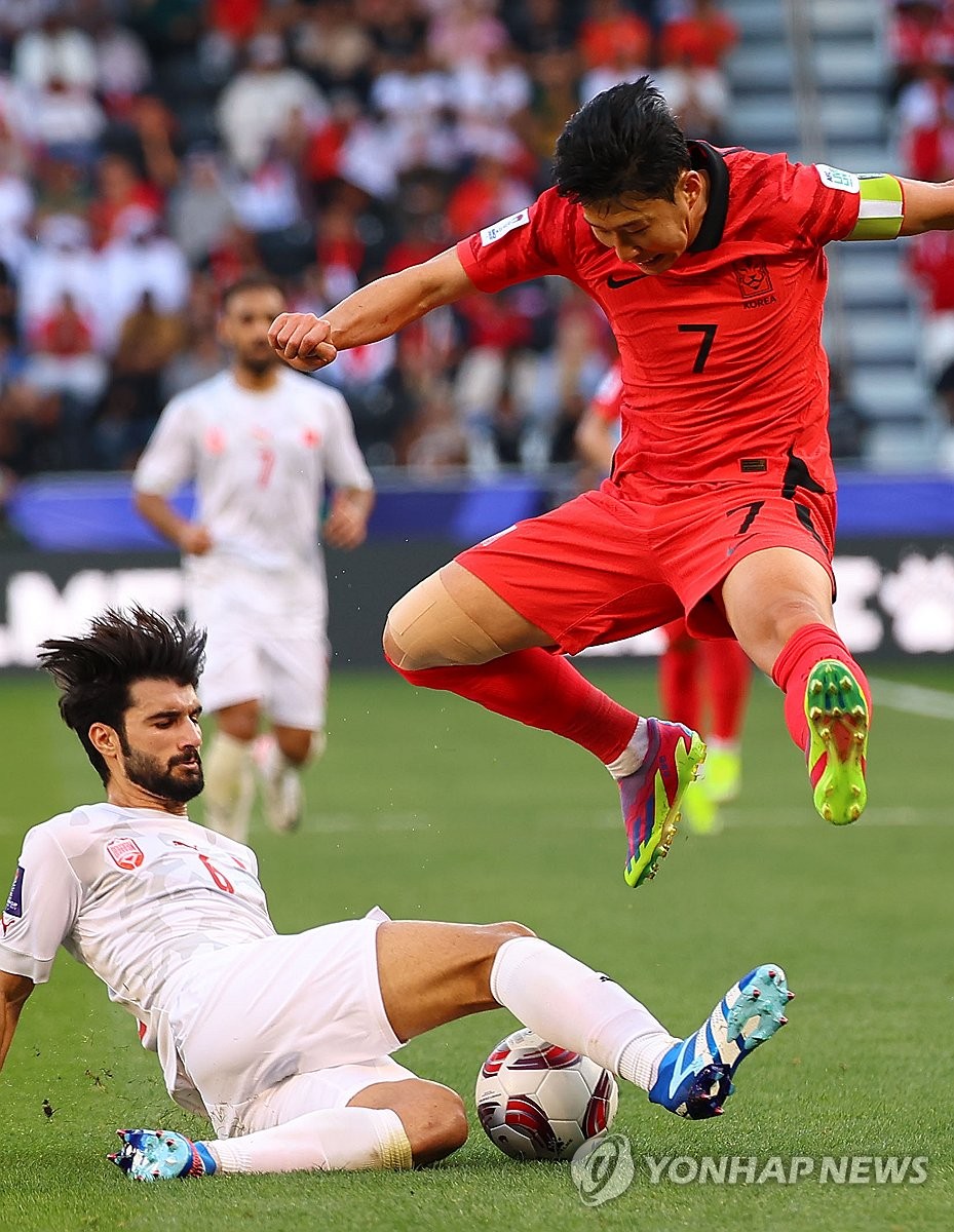 South Korea's Son Heung-min (right) avoids a tackle by Bahrain's Mohamed Al Hadan during the Asian Football Confederation Asian Cup Group E match at Jassim Bin Hamad Stadium in Doha on January 15, 2024. ) (Yonhap News)